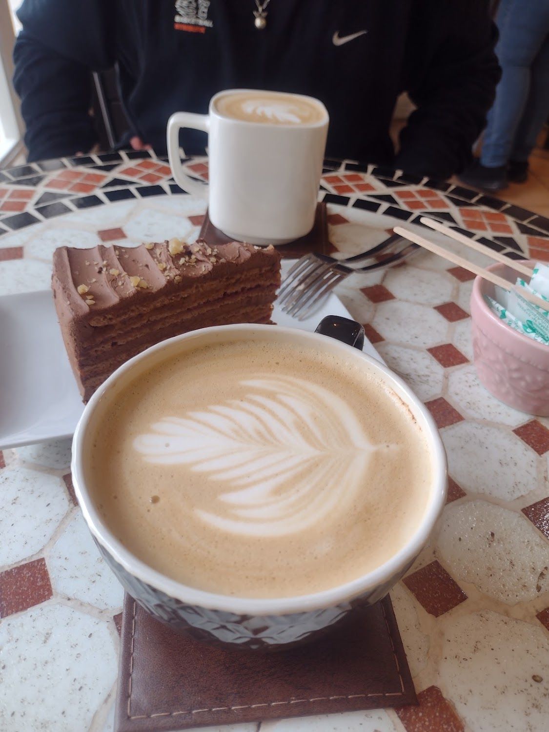 Torta de chocolate junto a un capuchino