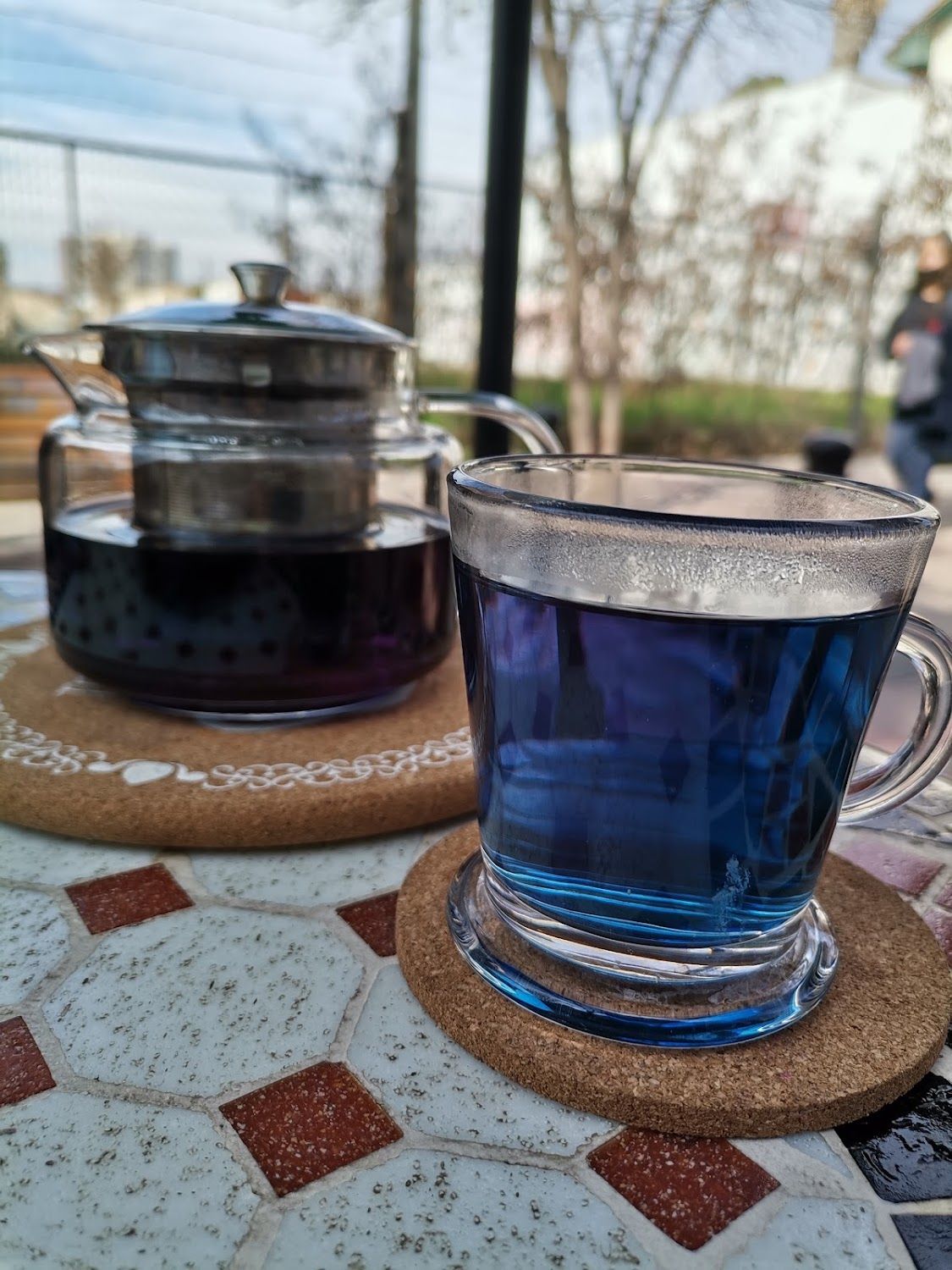 Té azul de flores servido en taza de vidrio