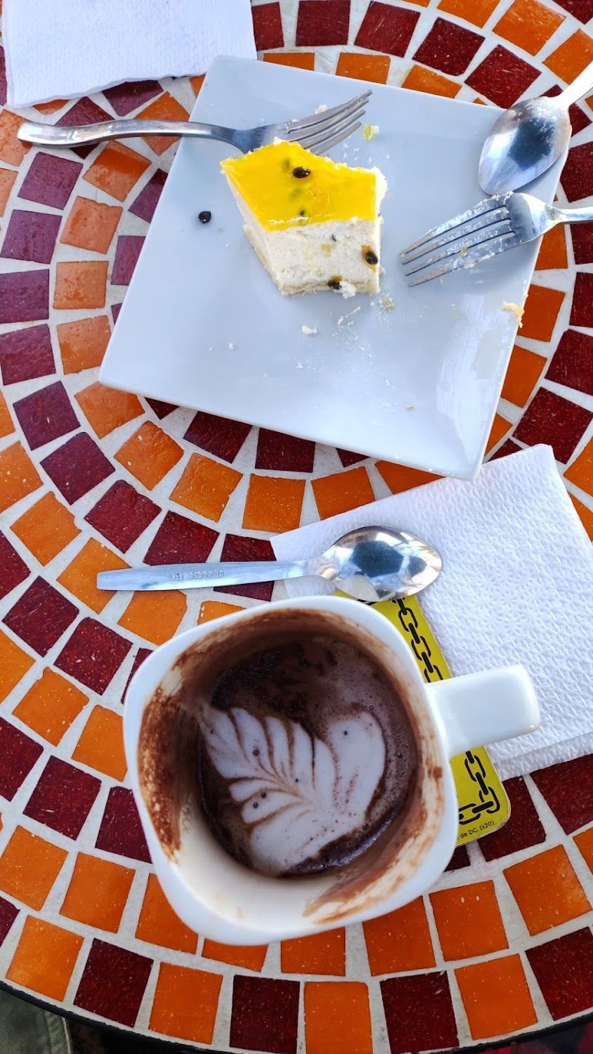 Trozo de torta y taza sobre la mesa de mosaico