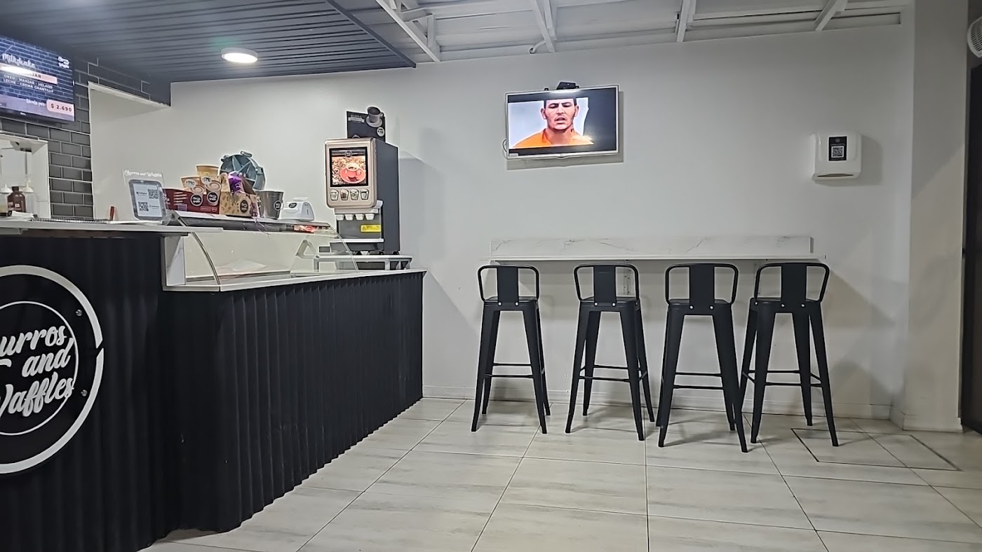 Interior de Churros and Waffles con su mesón y el logo